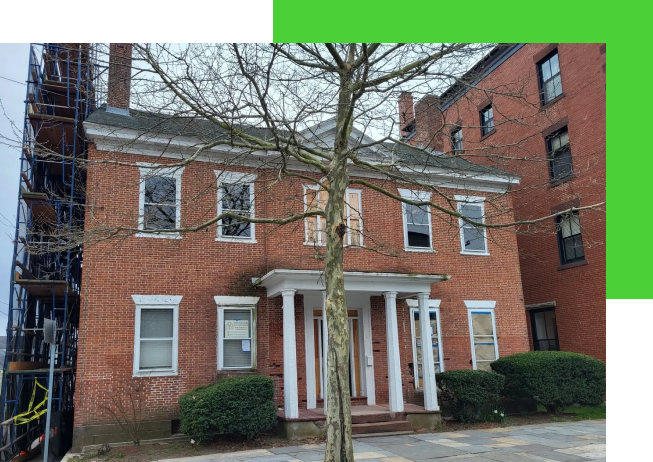 A brick building with a tree in front of it.